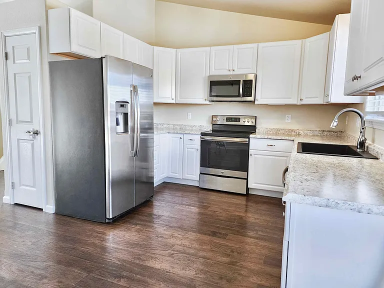 The kitchen is complete with modern appliances and granite sink. The clean cupboards make space to organize your things