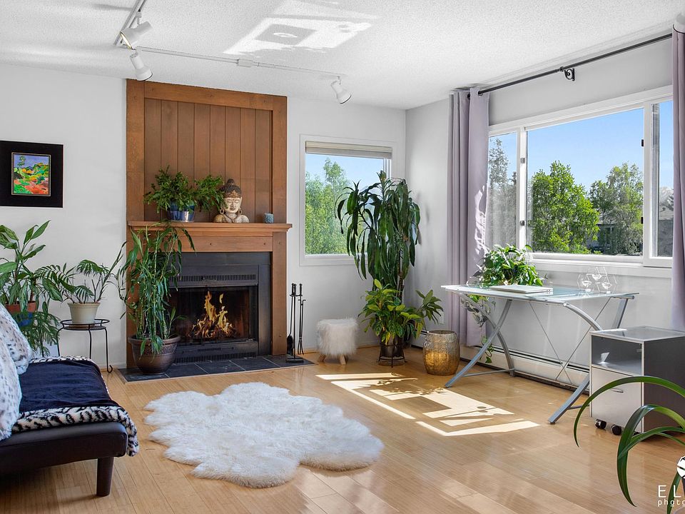 Living room with plenty of sunlight and fireplace.