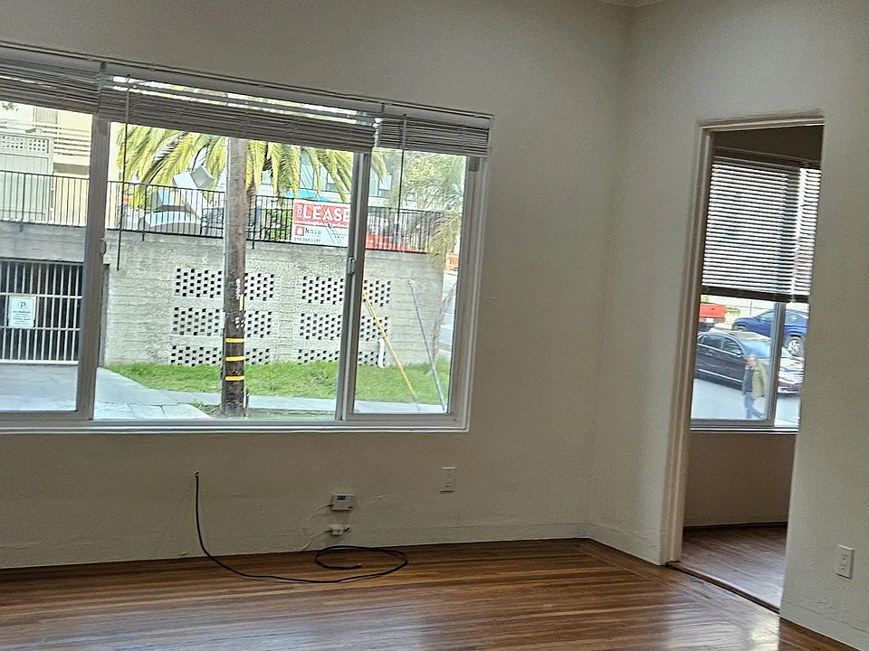 Main room with east facing windows and a door to the kitchen