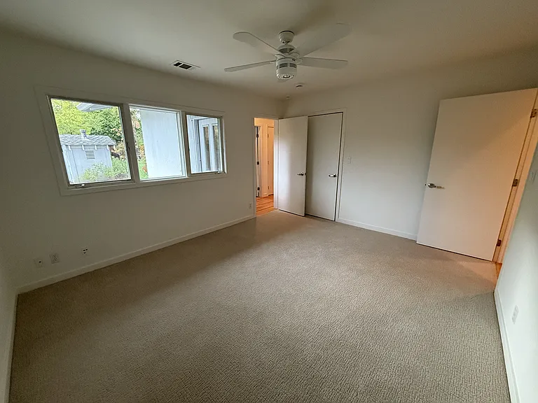 First bedroom has ceiling fan, spacious closet and comfortable plush carpet.