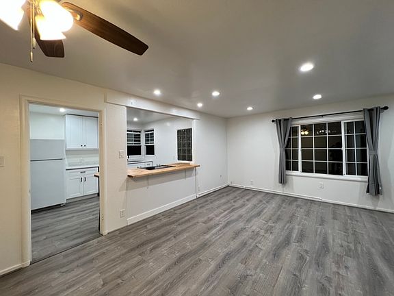 Open floor plan with living area and kitchen with seating for 2-3 people at counter