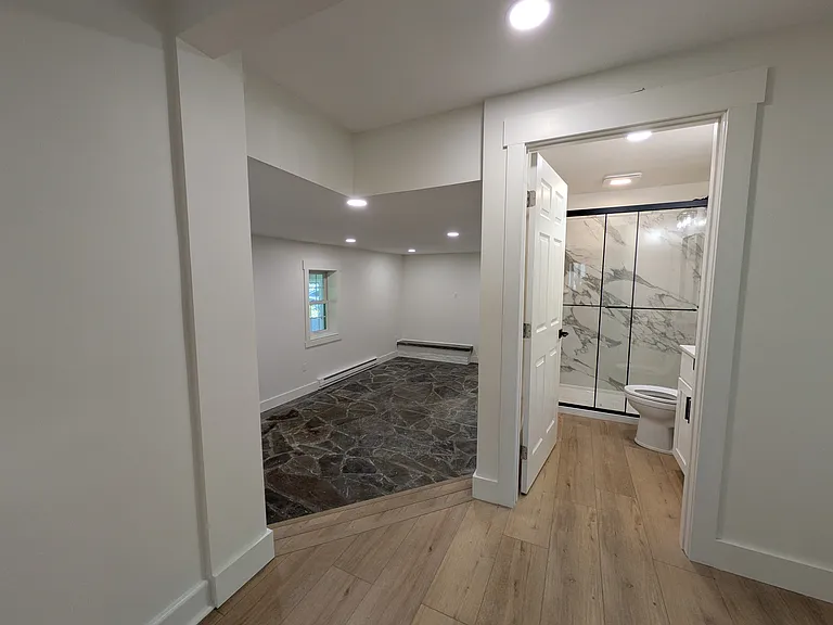 Full bathroom, Step down into the down and to the right is a bedroom.