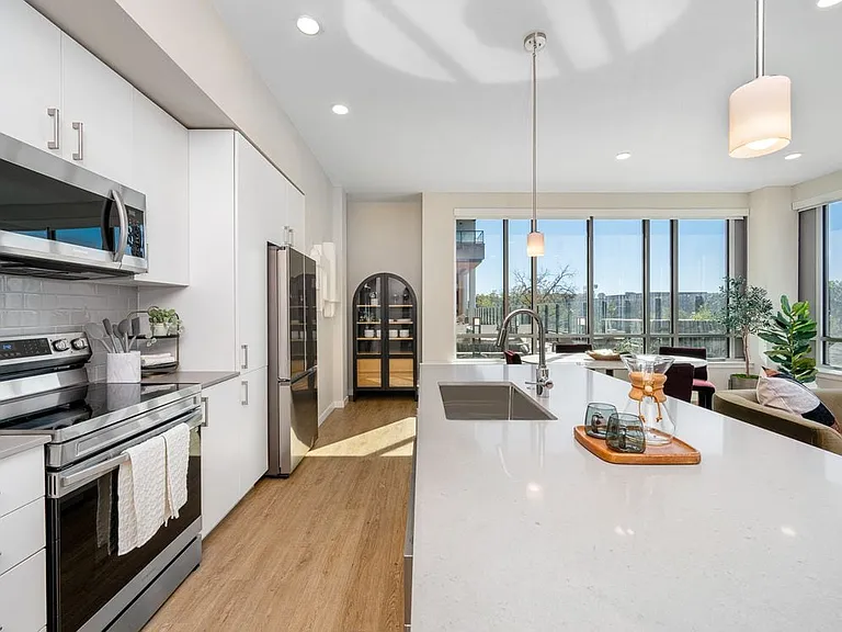 Finish Scheme I kitchen with grey quartz countertops, white cabinetry, grey subway tile backsplash, stainless steel appliances, and hard surface flooring