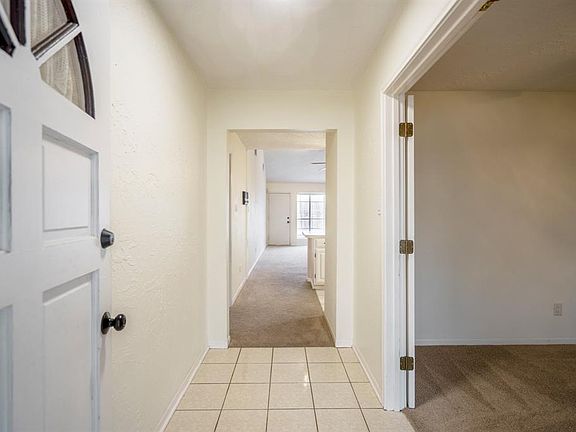 Let's head inside! This first view into the home we see the lovely neutral tile of the entrance & the transition to carpet leading out.