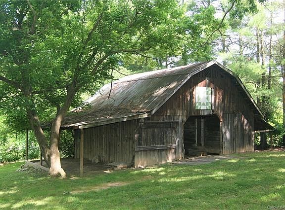 Expansive fenced in back yard with old growth oaks and early 20th Century Dairy Barn.