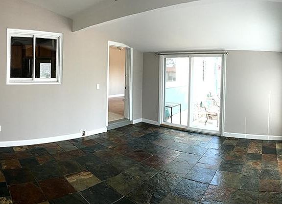 Bonus sunroom with slate tile floor and ceiling fan. Lots of