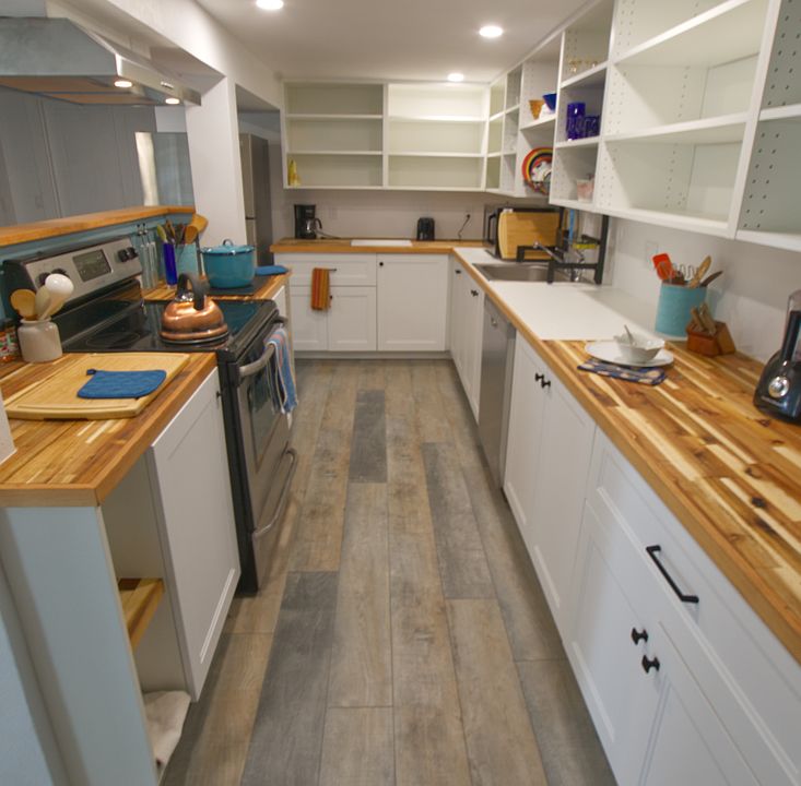Kitchen counters are oiled butcher block and there's lots of open shelving for your pantry and personal items