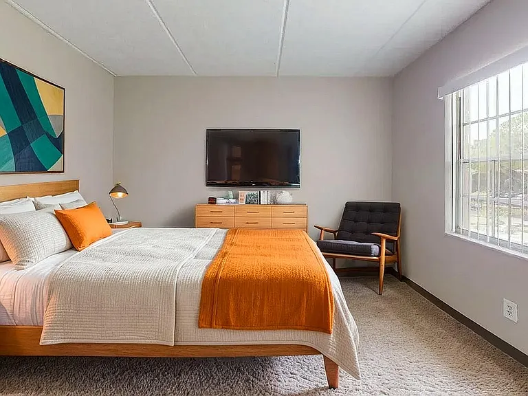 Modern bedroom with cozy double bed, vibrant decor, large window with natural light, and stylish furnishings.