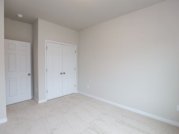 Empty room with beige carpet, white walls, and closet-perfect for new homes in Richmond VA.