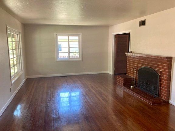 Living room with brick fireplace and plenty of natural light.