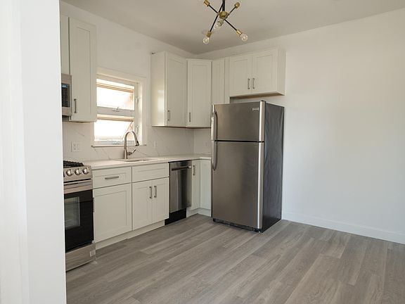 Brand new gut renovated kitchen - complete with dishwasher, under cabinet lighting, high end light fixtures, marble look quartz counter tops, etc