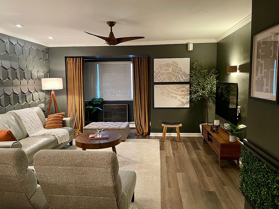 Roomy living room with modern decor is bathed with sunlight during the day, a cozy relaxing space at night. Plenty of seating.