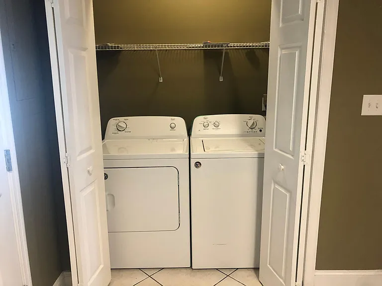 A full-size washer and dryer are located in a laundry area in the kitchen.