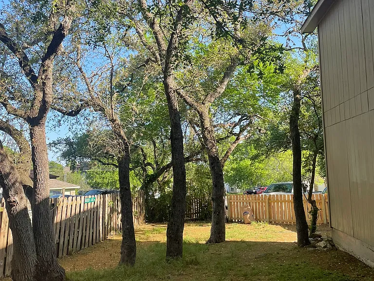 Fully fenced yard with mature trees and lots of pet play areas.