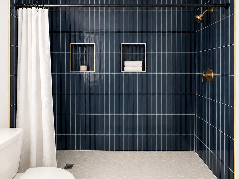 Walk-in tile shower with built-in niches and a curtain rod, plus sleek fixtures and easy-clean flooring.