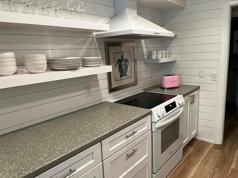 European styled kitchen with open shelving and hoof over the stove.