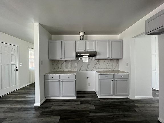 Kitchen with new vent hood, backsplash, countertops and refinished cabinets