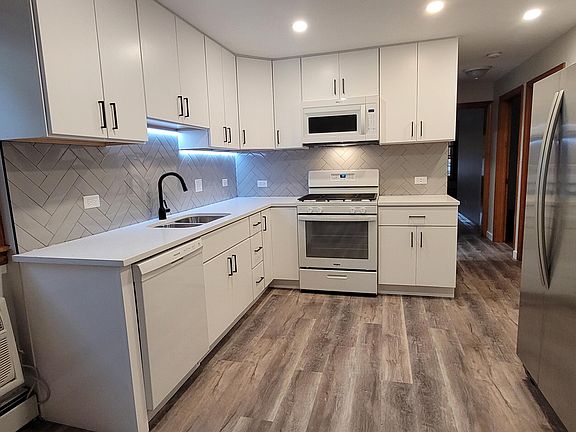New kitchen with quartz counter tops, built-in microwave and dishwasher