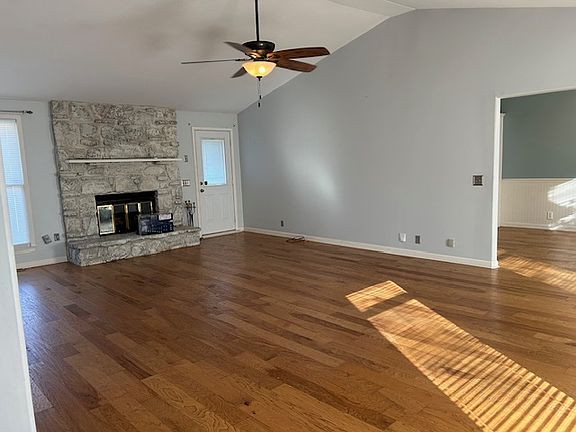 Huge living room with large stone wood burning fireplace.