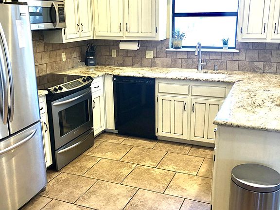 Beautifully updated kitchen with granite counter tops, large single basin sink, stainless steel appliances open to living room, dining room and breakfast eating area.