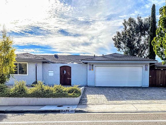 Front of home - Barn door opens to a small courtyard that has string lights, large secured mail and package box and cantilever umbrella.
