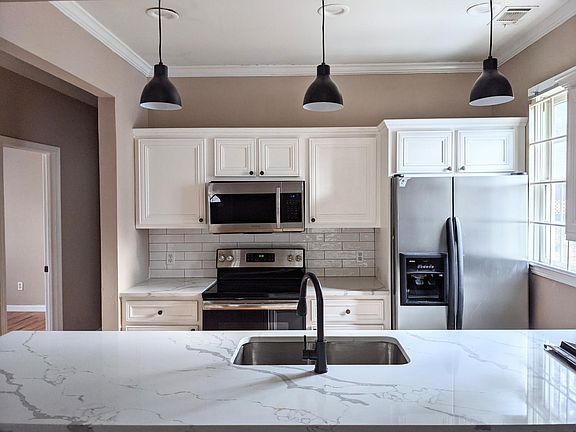 Renovated Kitchen with new Quartz countertops, faucet, subway tile backsplash and stainless appliances.