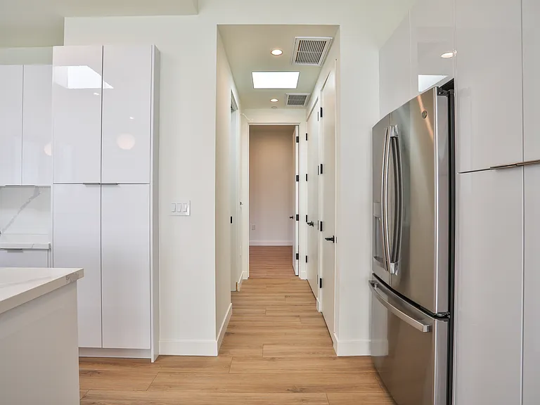 Corridor that leads to powder room, laundry, and bedroom