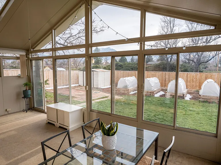 Sun room view of the garden Flatirons, back yard, raised garden beds, and second storage shed.