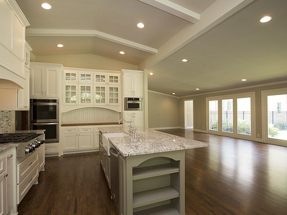 Magnificent open floor plan features breathtaking granite and stainless steel Kitchen complete with rich hardwood floors and beamed ceiling with recessed lighting.