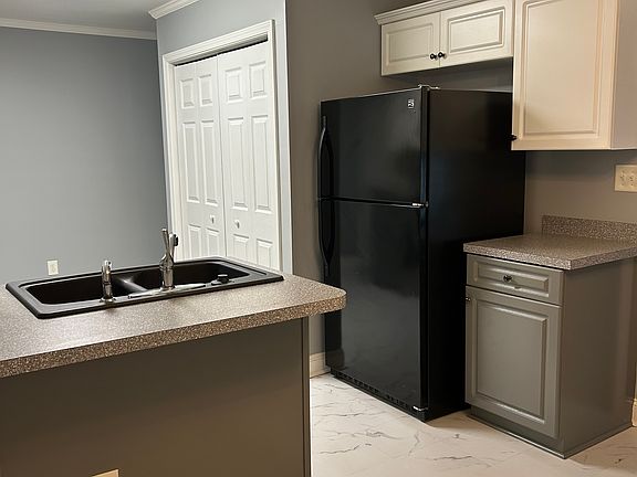 Large kitchen includes refrigerator, stove, built in microwave, dishwasher & laundry area; bar seating