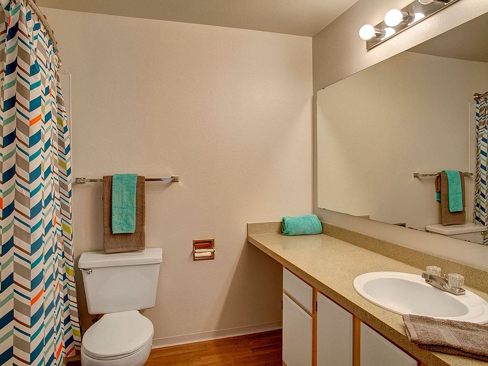 A large bathroom with a shower and tub, lots of cabinet storage, and a small vanity area