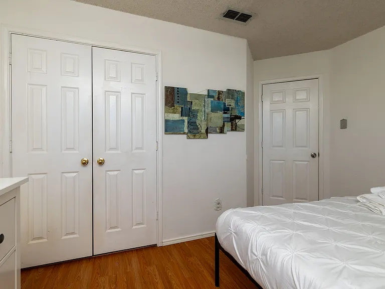 Stylish second bedroom with a queen bed and modern industrial touches.