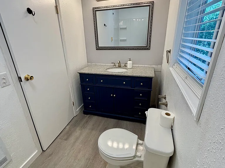Ensuite bath with spa tub, vanity, and window