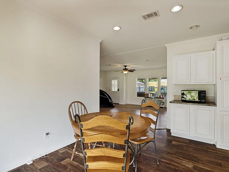 Eat-in kitchen space with white cabinetry, durable counters, and room for a dining table, flowing into the main living area.