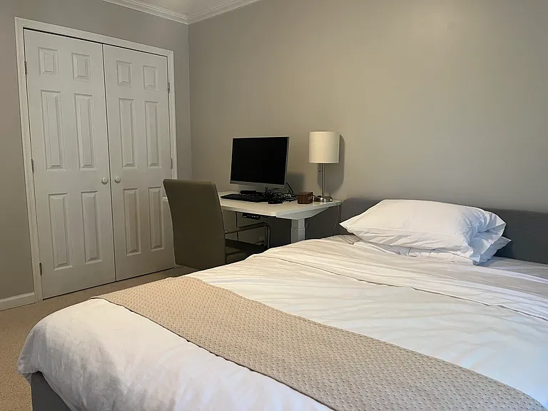 Second bedroom with a queen-size bed and an electric standing desk