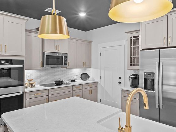 Exceptional kitchen featuring a spacious island, eye-catching pendant lights, and modern finishes at