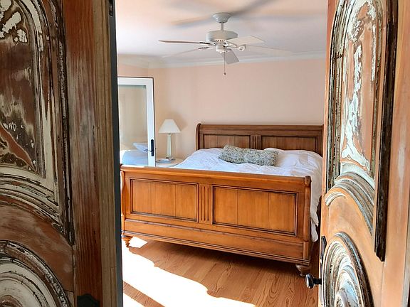 King bed with wall in closet. Antique doors, and French doors to large deck.