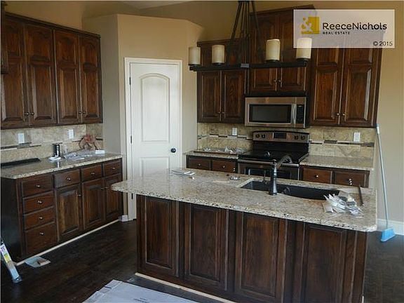 Beautiful kitchen with dark stained cabinets, stainless steel appliances and large walk-in pantry.