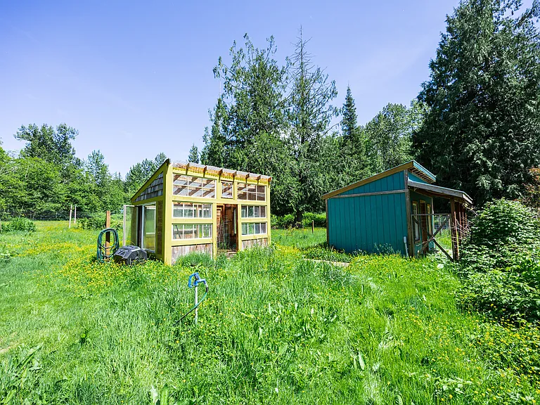 Fenced Garden area with greenhouse inside of it.