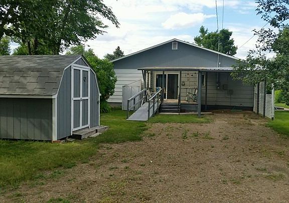 Back of Home : Large covered parking area and covered back deck. Outdoor storage area.