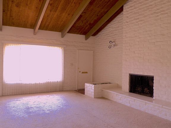 Large living room with raised wood burning/gas fireplace, large windows and 20ft cathedral ceilings.