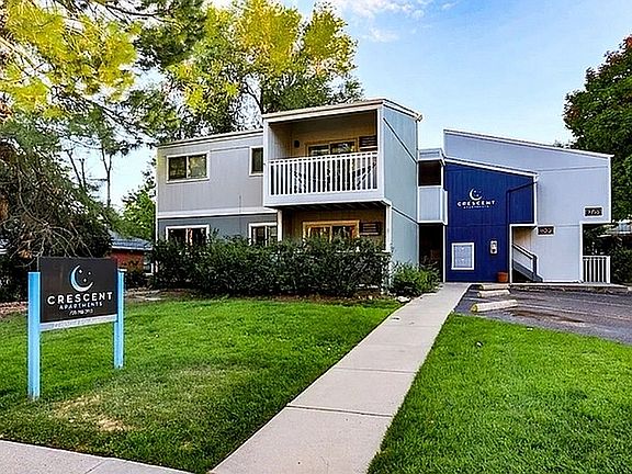 Charming Crescent Apartments exterior showcasing modern architecture with lush greenery and a welcoming entrance.