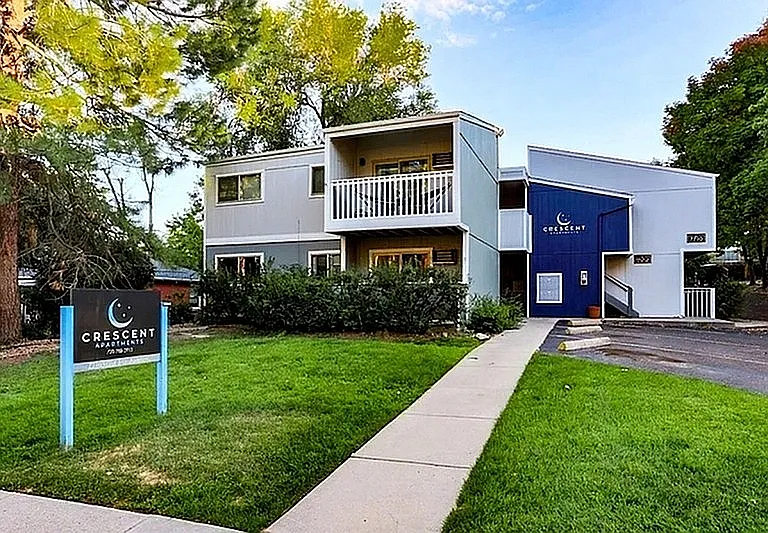 Charming Crescent Apartments exterior showcasing modern architecture with lush greenery and a welcoming entrance.