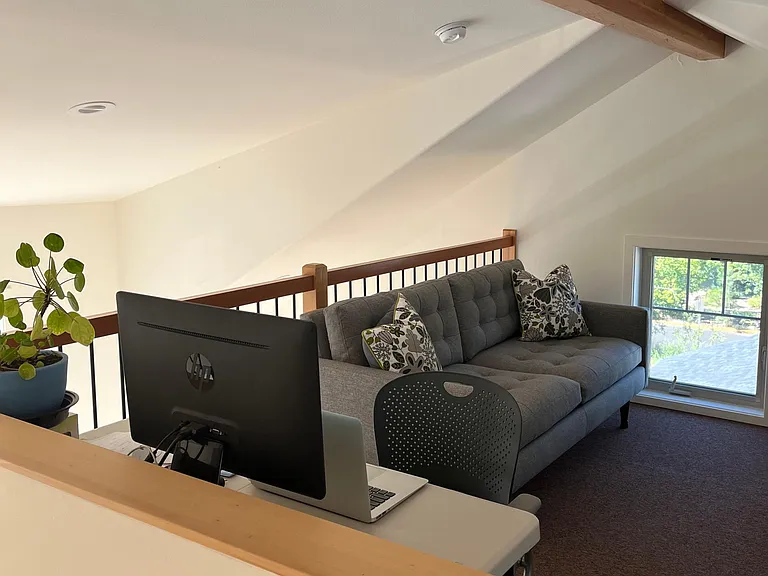 Loft area with dedicated work-from-home space with desk and Herman Miller office chair. Large sofa for lounging and reading.