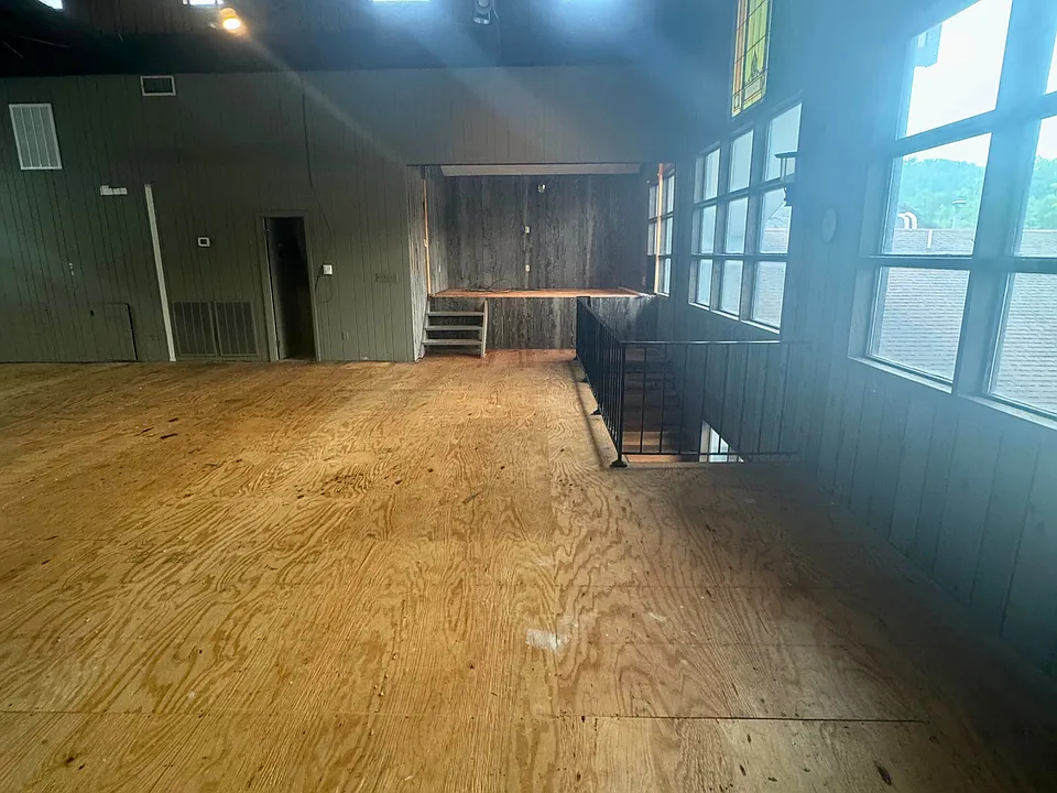 Interior view: large, open layout with high ceilings. Staircase leading down, gives access to 2nd entrance.