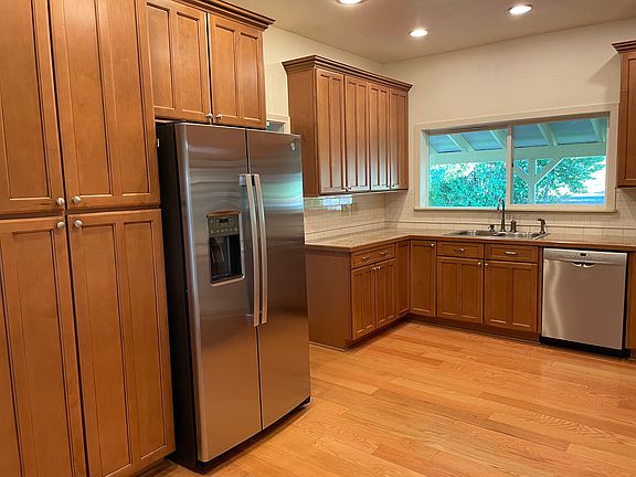 Large country kitchen with upscale cabinets with pull out drawers, granite counter tops with Italian tiled back splash, cook top, double ovens. Appliances are top brands. Hardwood flooring completes this dream kitchen.