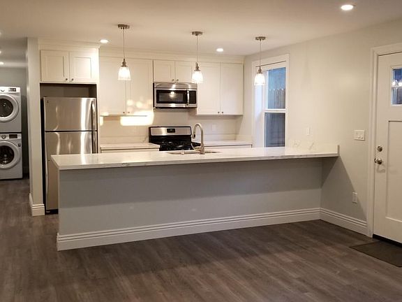 spacious open plan kitchen with brand new stainless steel ap
