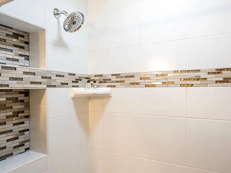 Bathroom has a ton of hooks, towel bars for hanging towels, clothes. medicine cabinet and bathroom cabinet with drawers.