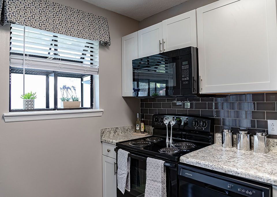 Kitchen with black appliances and natural light at Forest Ridge apartments for rent in North Macon, GA