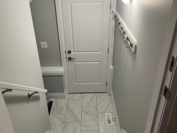 Boot room landing with built in coat rack.